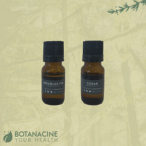 two 10 ml essential oil bottles with black lids and green labels that read Douglas fir and cedar